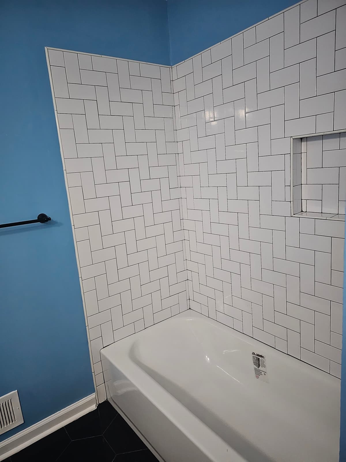 White subway tile shower with a blue accent wall