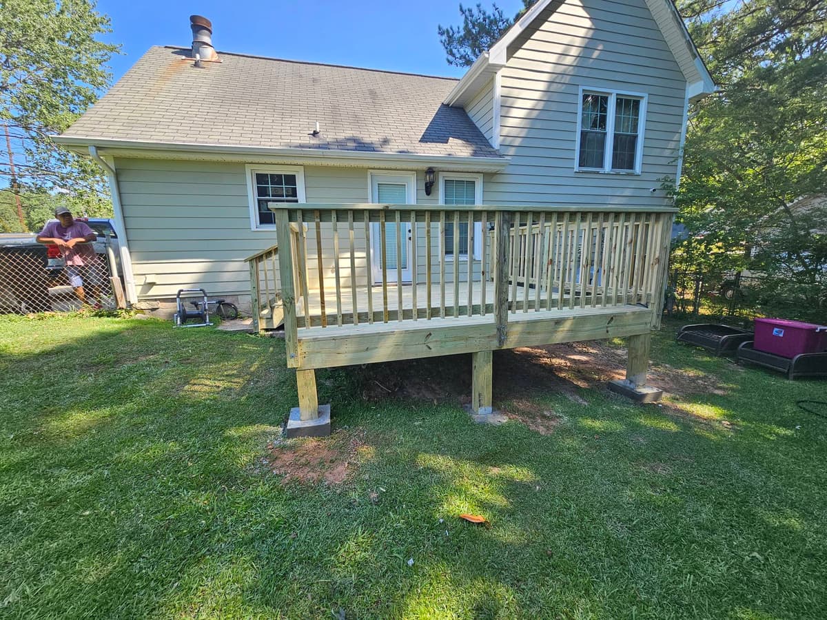 New wood deck with railing on a brick home